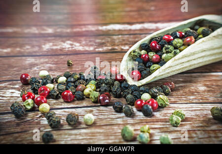 Gemischte getrocknete Pfefferkörner auf einem Holzlöffel. Stockfoto