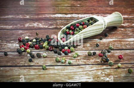 Gemischte getrocknete Pfefferkörner auf einem Holzlöffel. Stockfoto