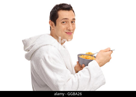 Profil von Schuss von einem jungen Mann essen Müsli aus einer Schüssel isoliert auf weißem Hintergrund Stockfoto