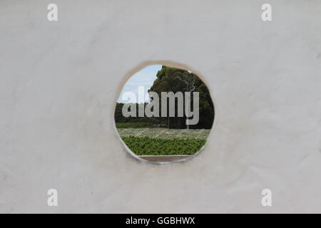 Blick durch ein Loch in der Wand in den Weinbergen bei Voyager Estate, Margaret River, Australien Stockfoto