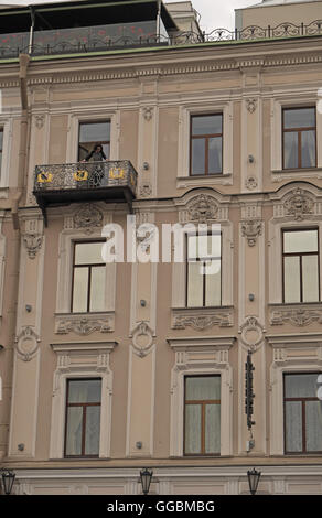 Dame auf einem Balkon, der eines der schönsten Gebäude neben Fluss Fontanka, St Petersburg, Russland. Stockfoto