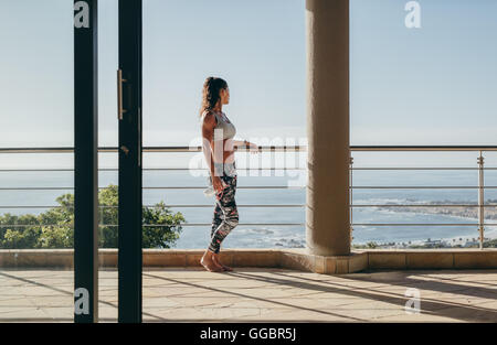 Im Freien Schuss der jungen Frau auf dem Balkon stehen und blickte auf den Blick. Stockfoto