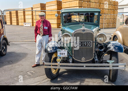 Klassischer Jahrgang 1930 Ford Grün motor Limousine und Fahrer, die in den 1930er Jahren Kleidung gekleidet würde zahlende Passagiere chauffeur rund um Stockfoto