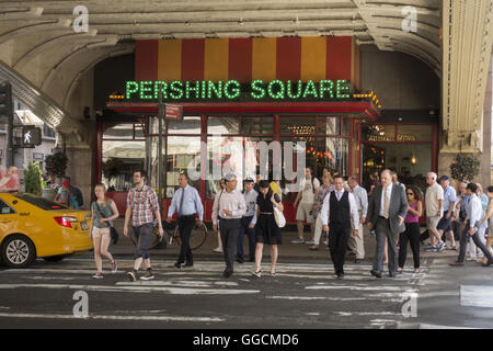 Menschen überqueren 42nd Street unter der Überführung der Park Avenue an der Grand Central Station in New York City. Stockfoto