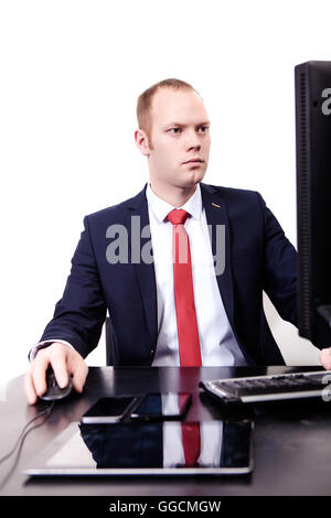 Glücklich Kaufmann arbeitet in seinem Büro mit Laptop. Lächelnde Jüngling sitzt an seinem Arbeitsplatz mit Notebook Stockfoto