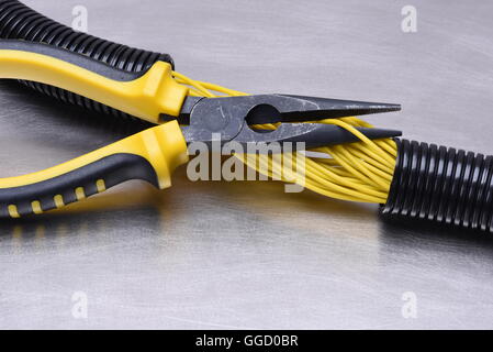 Elektrische Werkzeuge und Kabel auf Metalloberfläche mit Platz für text Stockfoto