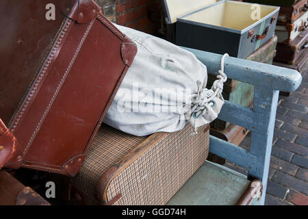 Alte Koffer in einem Dampfbahnhof stapelten sich auf einem Barkenkarren, auf dem Bahnsteig Stockfoto