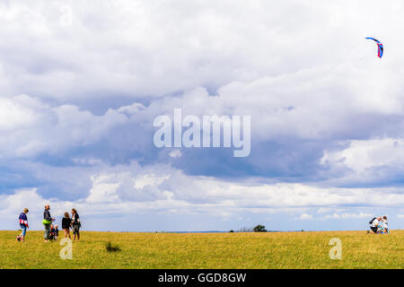 Kaseberga, Schweden - 1. August 2016: Echte Menschen im Alltag. Man Drachen in einem Feld mit Wolken im Hintergrund Stockfoto