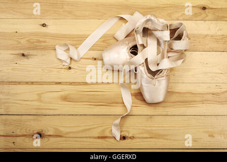 paar von Ballett Schuhe Pointes mit Bändern auf Holzboden Stockfoto