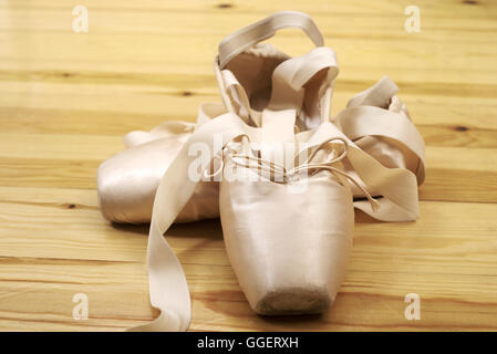 paar von Ballett Schuhe Pointes mit Bändern auf Holzboden Stockfoto