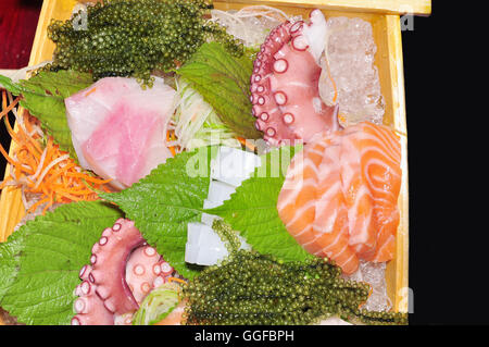 Ein Boot von Sushi mit Thunfisch, Lachs, grüne Kaviar und Oktopus Stockfoto