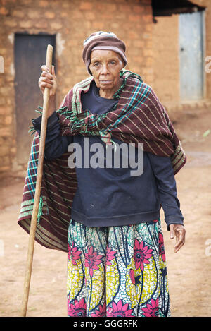 Porträt des ugandischen Seniorin hält einen groben gesägten Spazierstock Stockfoto