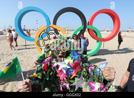 Ein Mann bedeckt in Blumen posiert für ein Foto vor der Olympischen Ringe an der Copacabana, Rio De Janeiro, Brasilien. PRESSEVERBAND Foto. Bild Datum: Freitag, 5. August 2016. Bildnachweis sollte lauten: Martin Rickett/PA Wire Stockfoto