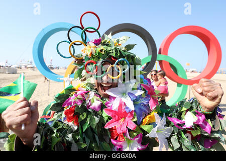 Ein Mann bedeckt in Blumen posiert für ein Foto vor der Olympischen Ringe an der Copacabana, Rio De Janeiro, Brasilien. PRESSEVERBAND Foto. Bild Datum: Freitag, 5. August 2016. Bildnachweis sollte lauten: Martin Rickett/PA Wire Stockfoto