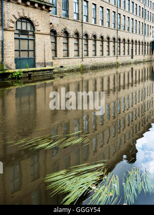 Salts Mill spiegelt sich in Leeds und Liverpool Canal an Saltaire West Yorkshire in England Stockfoto