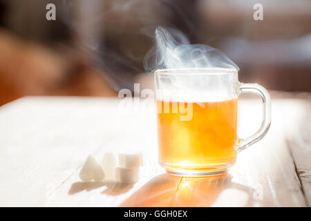 Glaskrug mit Tee am sonnigen Tag. Stockfoto