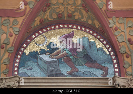 Allegorie des Silberbergbaus dargestellt, wie ein Zwerg, der silberne Truhe öffnet, in der Nacht. Allegorische Mosaik nach Entwurf von tschechischen Künstlers Mikolas Ales auf dem Zemska-Bank-Gebäude in Prag, Tschechien. Das Gebäude der Zemska Bank, später von der Zivnostenska Bank verwendet, wurde von tschechischen Architekten Osvald Polivka und 1894-1896 in Na Prikope Straße erbaut. Stockfoto