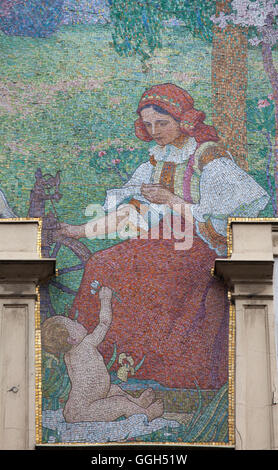 Junge Spinner mit dem Spinnrad. Detail des allegorischen Mosaiks personifiziert Textilindustrie und Handel nach dem Design von tschechischen symbolistischen Künstlers Jan Preisler am Haus Novak in Prag, Tschechien. Das Haus am Novak (Dum U Novaku) entworfen von tschechischen Architekten Osvald Polivka 1902-1903 in Vodickova Straße für tschechische Unternehmer Jan Novak als erstes erbaut immer Kaufhaus in Prag. Stockfoto