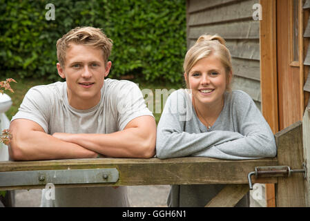 Porträt von einem Teenager-paar stützte sich auf ein Gartentor Stockfoto