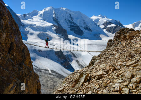 Frau auf einer Hängebrücke klettern die Klettersteige am Piz Trovat mit Blick auf Piz Palue (3905 m), Bellavista (3922 m) und pro Stockfoto
