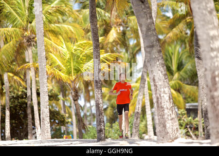 Junger Mann läuft entlang der palmengesäumten Strand, Dominica, kleine Antillen, Caribbean Stockfoto