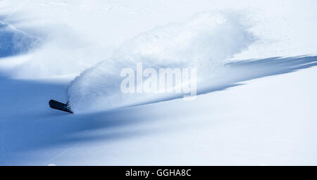 Junge männliche Snowboarder Reiten durch Tiefschnee in den Bergen, Pitztal, Tirol, Österreich Stockfoto