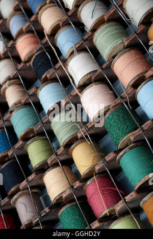 Walzen von farbigen Baumwolle gespeichert im europäischen Stil-Gestell, das an der Wand hängt Stockfoto