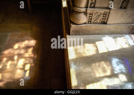 Licht kommt durch ein Glasfenster neben dekorativen Steinmetzarbeiten Stockfoto
