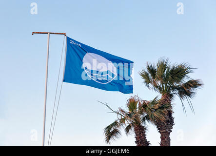 Blaue Flagge 2016 und Palmen Bäume gegen strahlend blauen Himmel bei Sonnenuntergang. Es ist ein Symbol der ökologischen Strände am Meer in Europa 20 Stockfoto