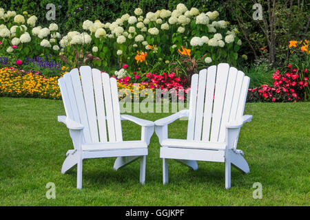 Adirondack Stühle im Blumengarten auf Mackinac Island, Michigan, USA Stockfoto