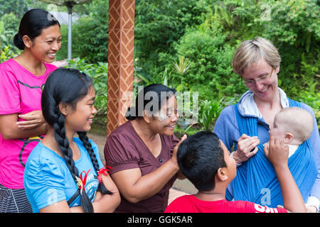 Balinesische Familie mit deutschen Baby, wickeln, Baby-Tragetuch bei ihrer Mutter, Baby 5 Monate alt, interkulturelle Kontakte spielen, treffen loca Stockfoto