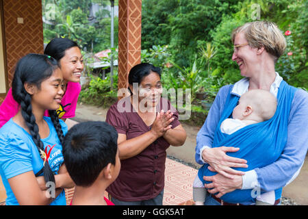Balinesische Familie mit deutschen Baby, wickeln, Baby-Tragetuch bei ihrer Mutter, Baby 5 Monate alt, interkulturelle Kontakte spielen, treffen loca Stockfoto
