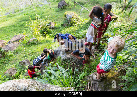 Deutsche Junge spielt mit indonesischen Kinder, kriechen, auf Felsen klettern, junge 3 Jahre alt, Dorf, Landschaft, Kinder, Stockfoto
