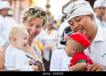 Balinesische Vater mit Kindern, deutsche Mutter mit Baby, Mädchen 5 Monate alt, zusammen zu spielen, lachen, Lächeln, Tempel-Zeremonie, Stockfoto