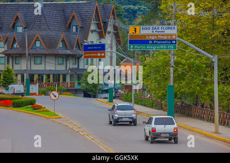 GRAMADO, Brasilien - 6. Mai 2016: Autos fahren auf der Straße, unterzeichnet als Hintergrund Gebäude, Stadt directios Stockfoto