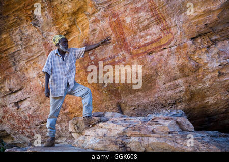 Aborigines Anleitung erklärt die Geschichte des traditionellen Wandmalereien, Arnhemland, Northern Territory, Australien Stockfoto