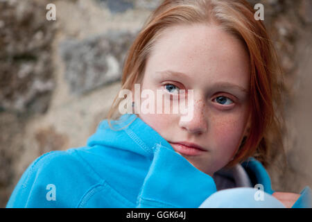 Rote behaarte Teenager-Mädchen mit blauen Pullover und blaue Augen Blick verträumt, Clonmacnoise, County Offaly, Irland, Europa Stockfoto