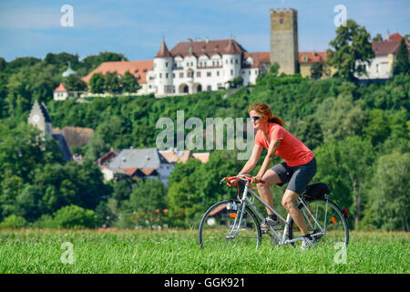 Radfahren, Frau Schloss Neubeuern im Hintergrund, Neubeuern, Upper Bavaria, Bavaria, Germany Stockfoto