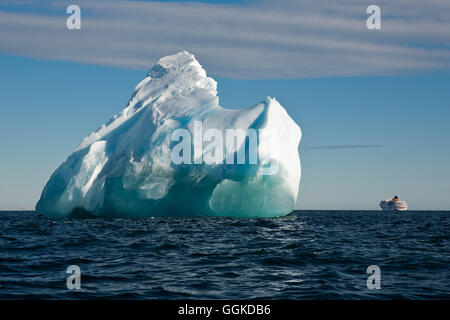 Eisberg in hellem Sonnenlicht mit Expedition Kreuzfahrtschiff MS Hanseatic (Hapag-Lloyd Kreuzfahrten) im Hintergrund, Vogel Punkt, Ross Stockfoto