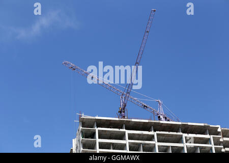 Kran auf ein Gebäude im Bau in Tag Zeit und blauen Himmelshintergrund arbeiten. Stockfoto