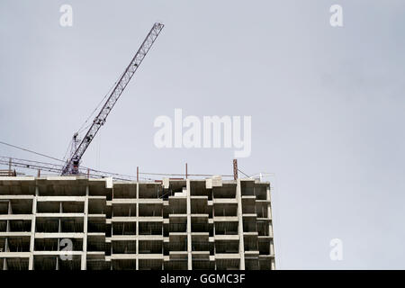 Kran arbeiten an einem Gebäude im Bau in grauen Hintergrund. Stockfoto