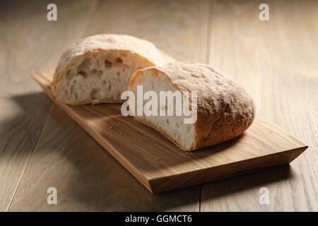 Hälften des frischen Ciabatta auf Oliven Schneidebrett Stockfoto