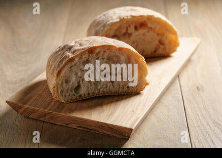 Hälften des frischen Ciabatta auf Oliven Schneidebrett Stockfoto