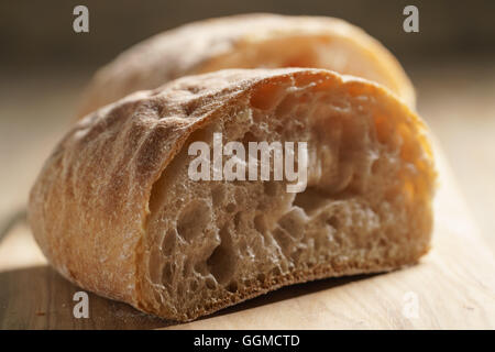 Hälften des frischen Ciabatta auf Oliven Schneidebrett Stockfoto