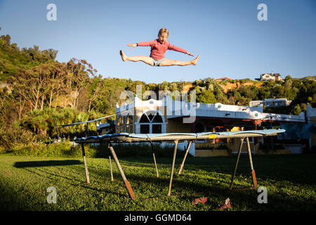 Ein Mädchen springen auf dem Trampolin am Sans Souci Inn, Pohara, Golden Bay, Südinsel, Neuseeland Stockfoto