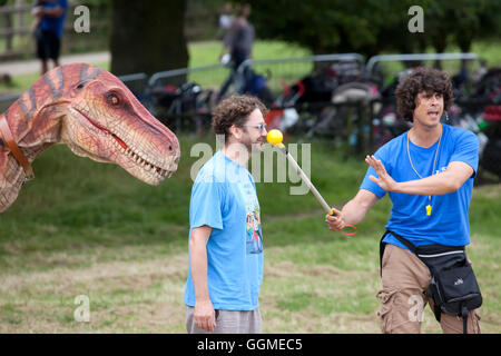 Hertfordshire, England, ca. Juli 2016, Andy Day, Schauspieler und Moderator der Tierwelt auf einen lebenden Dinosaurier zeigen Interaktion mit einem unkn Stockfoto