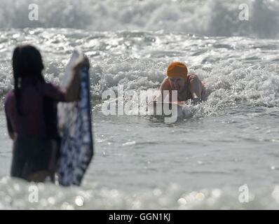 Ältere Frau genießt Bodyboarden Polzeath Strand, Cornwall, UK Stockfoto