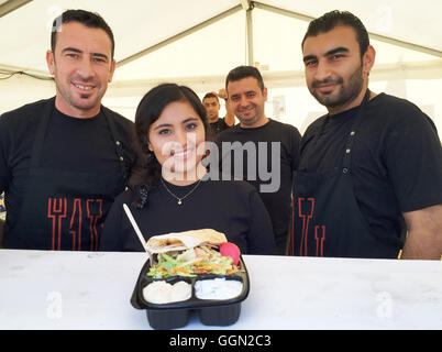 Skanderborg, Dänemark. 5. August 2016. Eine Gruppe von syrischen Flüchtlingen stehen an einem Imbiss-Stand und zeigen die syrischen Reisgericht 'Kabsa' beim 'Smukfest' Music Festival in Skanderborg, Dänemark, 5. August 2016. Foto: JULIA WAESCHENBACH/Dpa/Alamy Live News Stockfoto