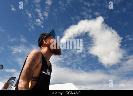 Vapefest das Festival für Vaping-Enthusiasten in Shrewsbury UK 6. August 2016. Richard Gregory von Coventry, Gewinner der „Battle of the Clouds“ für die Schaffung der größten Dampfwolke, atmet eine Dampfwolke gegen den blauen Himmel aus. Bild: David Bagnall/Alamy Live News dampfender Mann blauer Himmel raucht ausatmenden Rauch Stockfoto