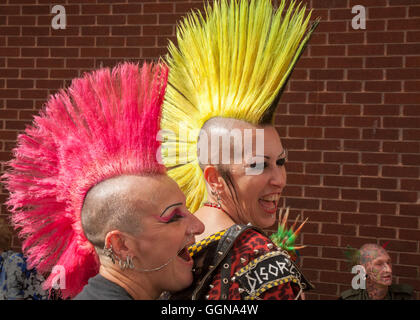 Ein Paar mit Mohawk oder Mohican Frisur mit Kopf rasiert. 20th Anniversary Rebellion fest kehrte als eines der größten Punk Festivals der Welt in die Blackpool Winter Gardens zurück. Spikyhaired Punks mit Mohican Haar versammelt auf dem größten Alternative-Musik-Festival in Großbritannien. Beim Rebellion Festival treten jedes Jahr hart rockende Punk-Bands in Blackpool’s Winter Gardens auf die Bühne, um die jubelnden Massen zu erfreuen. Die Straßen des Resorts sind in jeder Farbe des Regenbogens gestrichen, während lebenslange Punk-Fans mit lebhaft gefärbten Mohawks, rot-gelben spiky mohican Lederjacken zum Festival strömen Stockfoto